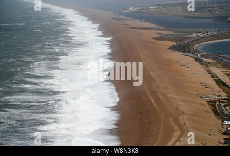 Les vagues déferlent contre Chesil Beach dans le Dorset que le Met Office a mis en place des avertissements d'orages jaune en Écosse et en Irlande du Nord et pour des vents forts à travers le pays de Galles et la plupart de l'Angleterre. Banque D'Images