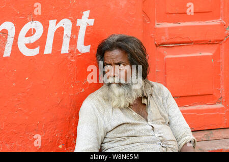 Un homme est assis sur le trottoir dans les petites rues de Varanasi, Uttar Pradesh, Inde, Asie du Sud. Également connu sous le nom de Bénarès, Bénarès et Kashi. Banque D'Images