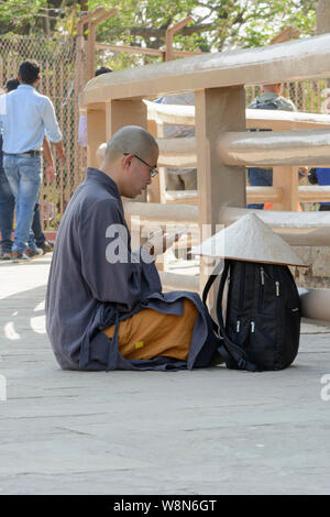 Le Bouddhisme dans l'âge moderne. Un moine se lit écrits Bouddhistes sur un téléphone mobile app, Mulagandha Kuti Vihara, Sarnath, Uttar Pradesh, Inde Banque D'Images