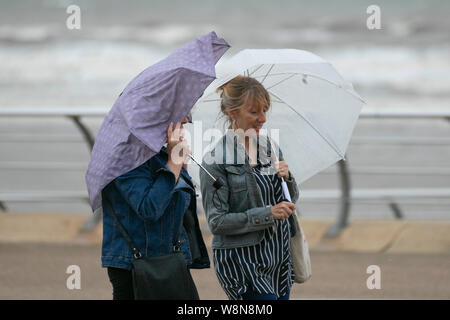 Blackpool, Lancashire. Météo Royaume-Uni. Août 2019. Avertissements météorologiques en place pour les vents forts et les fortes pluies, les touristes à la station bravent les conditions non saisonnières. Les visiteurs de la ville de bord de mer doivent supporter des vents violents sur la promenade de bord de mer soufflent, tente, cheveux volants, tresses enchevêtrées, un mauvais cheveux jour à la côte. Credit:MediaWorldImages/AlamyLiveNews. Banque D'Images