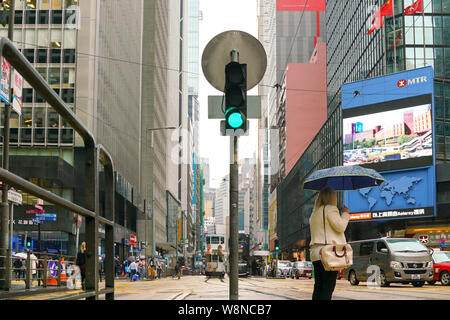 Central, Hong Kong-14th March 2019 : Les gens qui marchent dans la rue au feu de circulation Junction, sur un jour de pluie. Banque D'Images