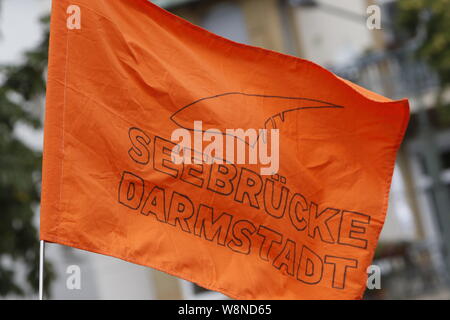 Francfort, Allemagne. 10 août 2019. Hisser un drapeau des manifestants qui lit 'eebrucke Darmstadt'. Des centaines de militants ont défilé dans Seebrucke Francfort, à appeler pour enregistrer les réfugiés ont été visités et la fourniture de ports pour enregistrer les réfugiés en Europe. La manifestation sous le slogan "s'unir pour la solidarité' a appelé à la solidarité avec tous les réfugiés et les volontaires sur des missions de sauvetage en mer en Méditerranée. À la fin de la protestation, ils ont bloqué la rivière Main avec divers dispositifs gonflables. Banque D'Images