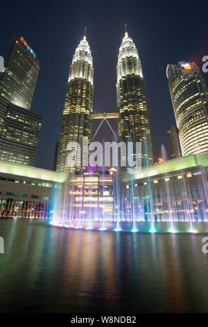 Les Tours Petronas au crépuscule avec fontaine de couleur Banque D'Images