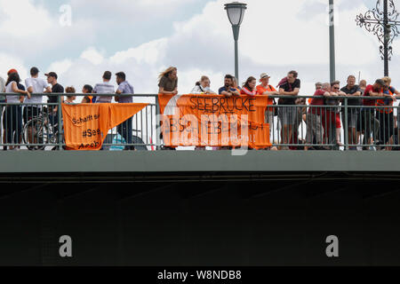 Francfort, Allemagne. 10 août 2019. Les manifestants ont accroché bannière sur le Vieux Pont, qui se lit "eebrucke (Mer pont) au lieu de la prison d'expulsion". Des centaines de militants ont défilé dans Seebrucke Francfort, à appeler pour enregistrer les réfugiés ont été visités et la fourniture de ports pour enregistrer les réfugiés en Europe. La manifestation sous le slogan "s'unir pour la solidarité' a appelé à la solidarité avec tous les réfugiés et les volontaires sur des missions de sauvetage en mer en Méditerranée. À la fin de la protestation, ils ont bloqué la rivière Main avec divers dispositifs gonflables. Banque D'Images