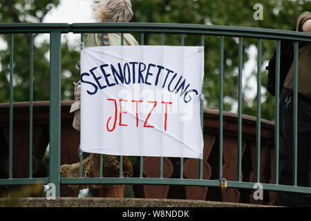 Francfort, Allemagne. 10 août 2019. Les manifestants ont accroché bannière sur le Vieux Pont, qui se lit "sauvetage" maintenant. Des centaines de militants ont défilé dans Seebrucke Francfort, à appeler pour enregistrer les réfugiés ont été visités et la fourniture de ports pour enregistrer les réfugiés en Europe. La manifestation sous le slogan "s'unir pour la solidarité' a appelé à la solidarité avec tous les réfugiés et les volontaires sur des missions de sauvetage en mer en Méditerranée. À la fin de la protestation, ils ont bloqué la rivière Main avec divers dispositifs gonflables. Banque D'Images