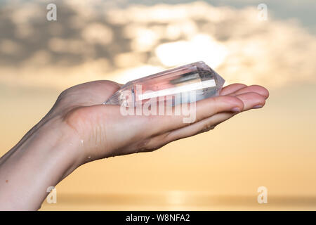 Vogel Style Double résilié Wand dans woman's hand au lever du soleil en face du lac. Banque D'Images