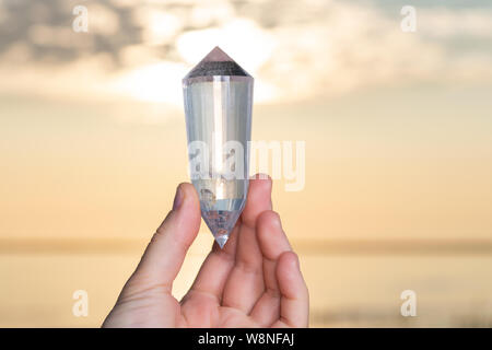 Vogel Style Double résilié Wand dans woman's hand au lever du soleil en face du lac. Banque D'Images