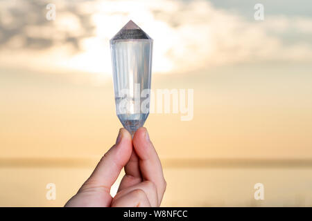 Vogel Style Double résilié Wand dans woman's hand au lever du soleil en face du lac. Banque D'Images