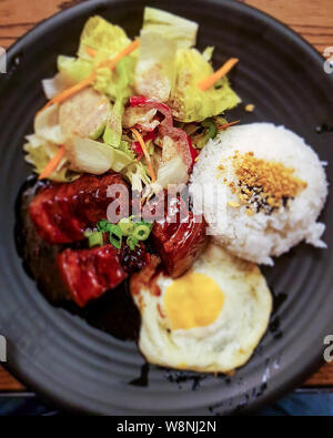 Détail d'un plat de ramen typique dans un restaurant japonais. Détail de mains du jeune homme. Banque D'Images