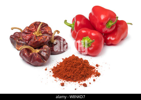 Frais et séchés poivrons rouge et un tas de poudre isolé sur fond blanc Banque D'Images