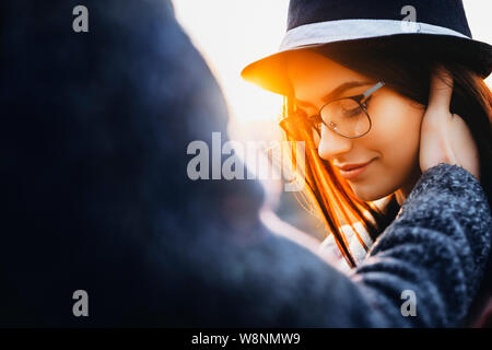 Main de l'homme anonyme touchant face de belle jeune femme dans l'élégant quartier de verres et hat.Petit hand touching face de femme Banque D'Images