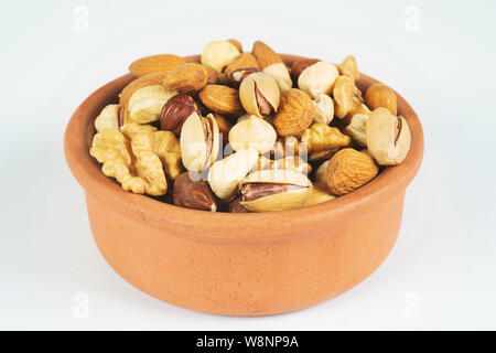 Bol avec noix mélangées sur fond blanc. L'alimentation saine et de snack. Noix, amandes, noisettes, noix de pécan et noix de cajou Banque D'Images