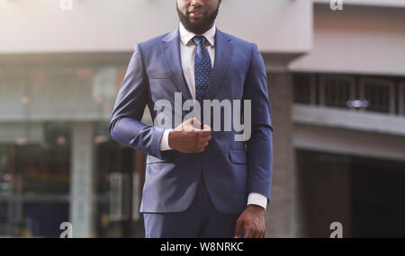 Jeune africain employé en costume standing outdoors Banque D'Images