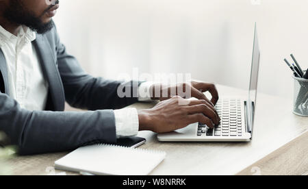 Méconnaissable businessman working on laptop in modern office Banque D'Images