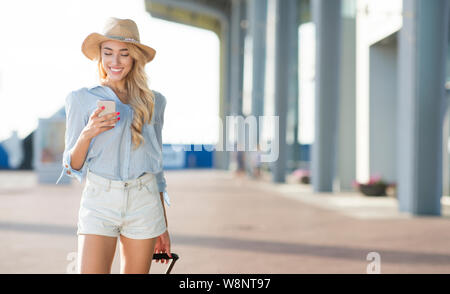 Billet d'air concept. Femme à l'aide de Phone, arrivant à airport Banque D'Images