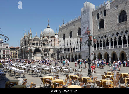 18 juin 2019, l'Italie, Venise : tables vides dans des restaurants de la Piazza San Marco à côté du Palais des Doges (Palazzo Ducale), r) et la Basilique Saint Marc (la basilique San Marco). Photo : Soeren Stache/dpa-Zentralbild/ZB Banque D'Images