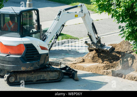 Avec la pose de câbles fibre optique grâce à une tranchée creusée par une route asphaltée Banque D'Images