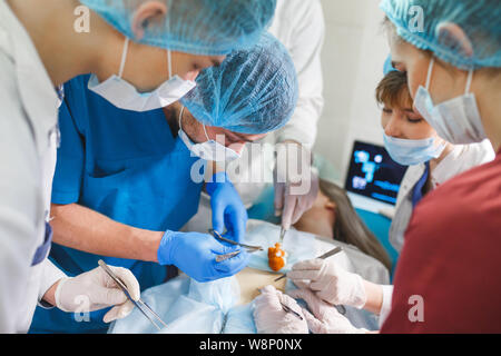 Groupe d'exploitation au travail des chirurgiens en chirurgie, dans le théâtre. L'équipe de médecine de réanimation portant des masques de protection Banque D'Images