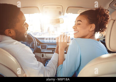 Heureux couple holding hands, voyageant en voiture Banque D'Images