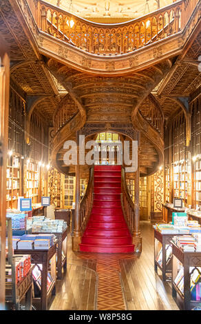 Grand escalier en bois avec des actions à l'intérieur rouge et Irmao Lello Bibliothèque dans le centre historique de Porto Banque D'Images