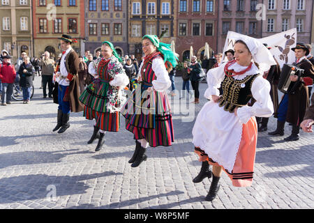 Les jeunes en costume traditionnel Lowicz dansent sur la place de la vieille ville de Varsovie. Danseurs habillés en costume folklorique polonaise. Banque D'Images