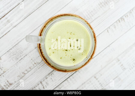 Thé vert matcha latte sur fond de bois blanc. Vue d'en haut. Banque D'Images