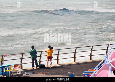 Plage de Chesil. 10 août 2019. Deux femmes bravent les spray, pour regarder les vagues gigantesques battues Chesil Beach, île de Portland. crédit : Stuart fretwell/Alamy Live News Banque D'Images