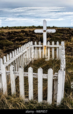 Picket fence et cross à tombe de français Alexandre Dugas qui s'est suicidé en 1929, l'île de Sea Lion, dans les îles Malouines, Atlantique Sud Banque D'Images