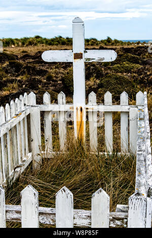 Picket fence et cross à tombe de français Alexandre Dugas qui s'est suicidé en 1929, l'île de Sea Lion, dans les îles Malouines, Atlantique Sud Banque D'Images