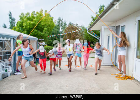 Odesa rgn. L'Ukraine, le 29 juillet 2018 : un groupe de jeunes filles sautant par une grosse corde, tordu de deux jeunes filles Banque D'Images