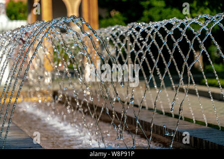 L'eau d'arrosage d'une fontaine avec des gouttes d'eau détaillée glinstering au soleil Banque D'Images