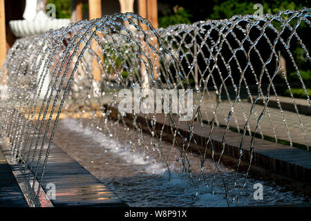 L'eau d'arrosage d'une fontaine avec des gouttes d'eau détaillée glinstering au soleil Banque D'Images