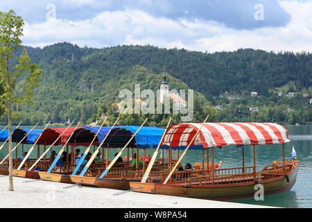 La Slovénie, Bled - Juillet 15, 2019 : le lac de bateaux. Beau lac de montagne en été avec petite église sur l'île et les Alpes en arrière-plan. Banque D'Images