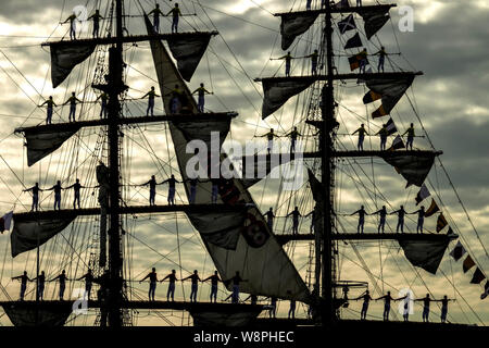 Silhouettes des marins de la marine colombienne Gloria grand voilier à permanent d'attention dans l'arrivée du navire pour le Hanse Sail-festival maritime, Trás Banque D'Images