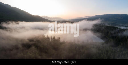 Vue panoramique aérienne du lac Fairy couvert de nuages pendant un été animé le lever du soleil. Pris près de Port Renfrew, l'île de Vancouver, Colombie-Britannique, Ca Banque D'Images