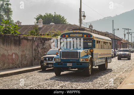 Bus de poulet classique, descendant une rue pavée, à Antigua, Guatemala Banque D'Images