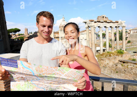 Les touristes détenteurs d'une carte de visite sur le Forum Romain voyage vacances à Rome, Italie. Happy tourist couple, homme et femme, voyageant sur les vacances en Europe smiling happy. L'Interracial Asian couple Banque D'Images