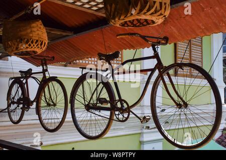 14 juillet 2019 PhilippinesSuspended- Vigan vintage bicycle. Un vieux millésime location suspendu au plafond d'un bâtiment rustique en bois Banque D'Images