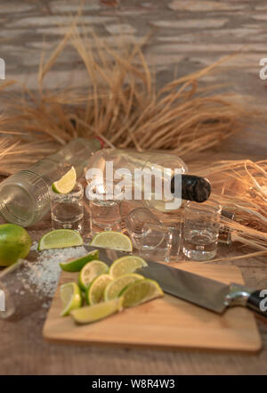 Photo détail de deux bouteilles de tequila, luxueux et prise de plusieurs tranches de citron avec du blé monte sur la table en bois - Vertical image Banque D'Images