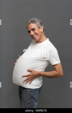 Homme âgé prétendant être une femme enceinte Banque D'Images