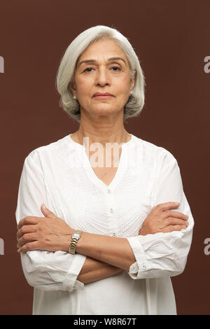 Portrait d'une femme âgée avec les bras croisés Banque D'Images