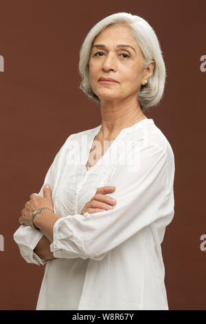 Portrait d'une femme âgée avec les bras croisés Banque D'Images