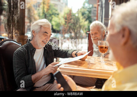 Trois hommes retraités célébrer leur réunion après l'âge Banque D'Images