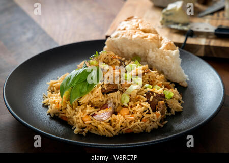 Pilaf ouzbek traditionnel fait maison ou plov sur une table en bois concept de cuisine orientale. Focus sélectif. Banque D'Images