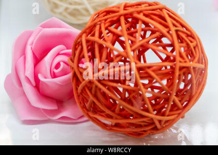 Première fleur sur blanc avec boule en rotin flou en premier plan Banque D'Images