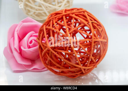 Première fleur sur blanc avec boule en rotin flou en premier plan Banque D'Images