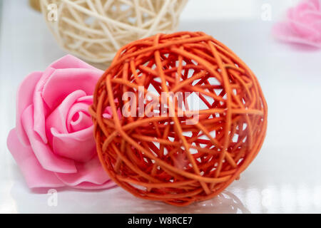 Première fleur sur blanc avec boule en rotin flou en premier plan Banque D'Images