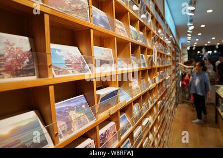 (190811) -- DALI, 11 août 2019 (Xinhua) -- Les touristes acheter des cartes postales à un magasin de souvenirs dans la vieille ville de Dali, le sud-ouest de la province chinoise du Yunnan, le 10 août 2019. Les touristes sont venus ici pour profiter charmante vue de nuit, la nourriture locale et des performances intéressantes au cours de la nuit. (Xinhua/Qin Qing) Banque D'Images