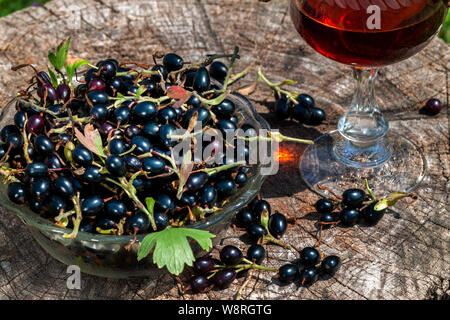 Vin de cassis avec des baies en verre avza à partir d'une vieille table en bois Banque D'Images