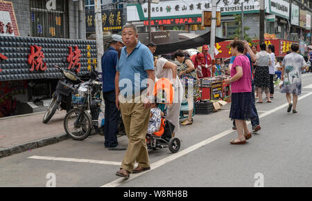 MISHAN, CHINE - 27 juillet 2019 : des personnes non identifiées, la vente et l'achat de produits dans un marché de légumes locaux. Mishan est une ville-district en Chine. Banque D'Images